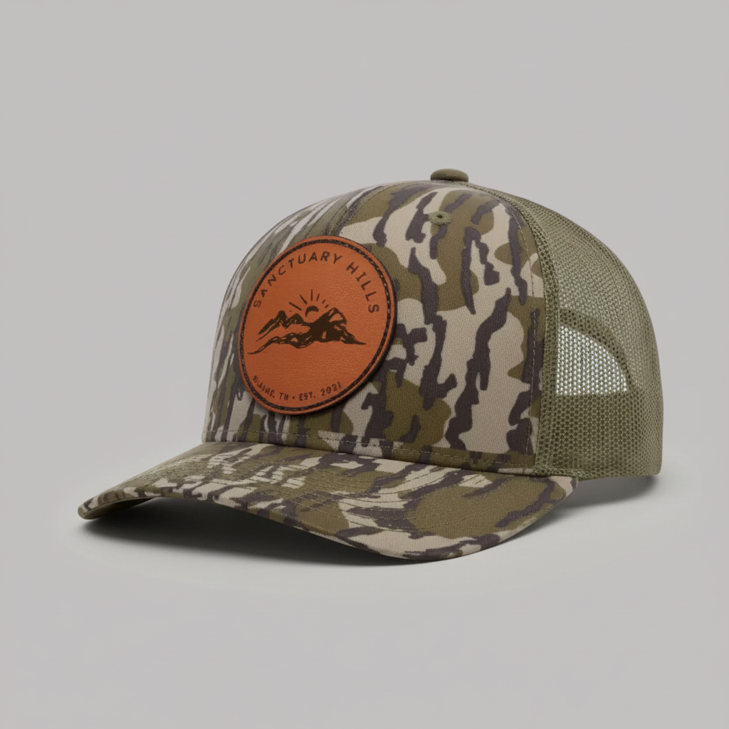 Camouflage baseball cap with a brown leather patch on a white background